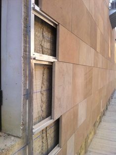 an open window on the side of a building that is being constructed into a wall