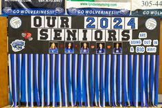 a group of blue and white banners with women's volleyball on them in front of a wooden wall