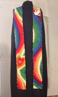 a colorful scarf hanging on a wall next to a coat hanger with a heart painted on it