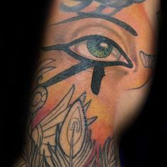 an egyptian eye tattoo on the left side of the arm and hand, with feathers around it