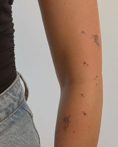 a woman's arm with small stars on it and the back of her leg