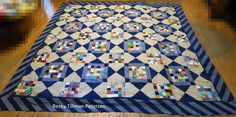 a blue and white quilt on the floor with wooden floors in front of it that has been made to look like an abstract pattern