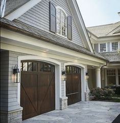 a house with two brown garage doors and windows