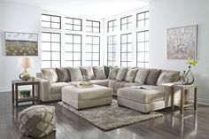 a living room filled with lots of furniture and decor on top of a hard wood floor