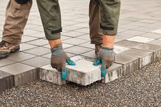 a person standing on top of a cement block with their feet in the air and wearing gloves