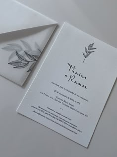 the wedding card is laying on top of an envelope and it has a watercolor leaf design