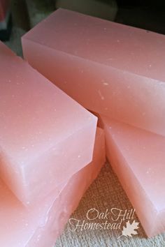 three bars of pink soap sitting on top of a carpeted floor next to each other