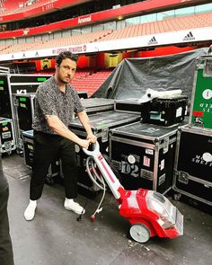 a man is using a vacuum to clean the floor in front of an empty stadium