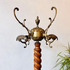 an ornately decorated wooden table lamp next to a potted plant