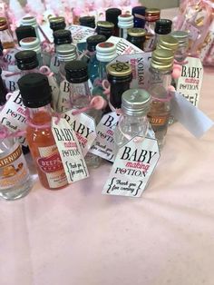 bottles of baby lotion sitting on top of a pink table cloth covered tablecloth