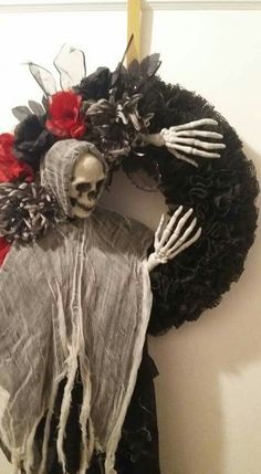 a wreath with a skeleton and flowers on it