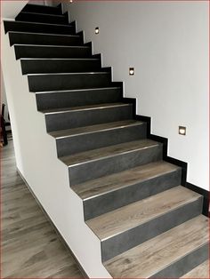 a set of stairs leading up to a second floor with white walls and wood floors