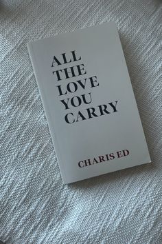 the book all the love you carry is laying on top of a white bed sheet