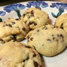 several chocolate chip cookies on a plate with blue and white flowered design around the edges