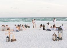 a group of people standing on top of a sandy beach