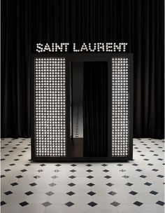 the entrance to saint laurent is lit up in black and white tiles with an illuminated sign above it