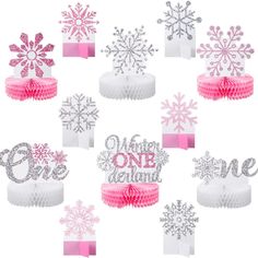 pink and silver snowflake cake toppers with the words winter one birthday on them