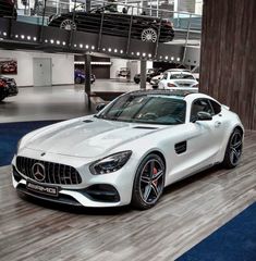 a white mercedes sports car on display in a showroom