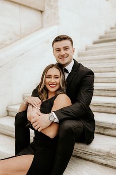 a man and woman are sitting on the steps together, posing for a photo with their arms around each other