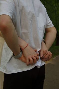 a man is holding his hands together while standing on the street