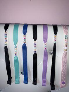 a bunch of ties are hanging on the back of a white purse that is attached to a wall