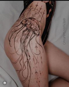 a woman's legs with tattoos on them and an image of a jellyfish