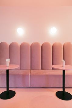 two round tables sitting next to each other on top of a pink couch in a room