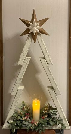 a wooden christmas tree with a lit candle