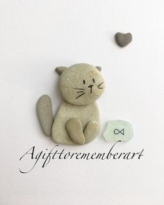 a stone cat sitting next to a rock with the word affittenmentment heart on it