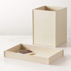 an empty box with a notepad and pen in it on a white countertop