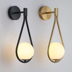 two lights on the wall next to each other in different shapes and sizes, one with a tear shaped light bulb