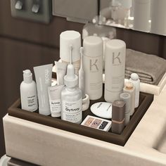 an assortment of personal care products are arranged on a tray in front of a mirror