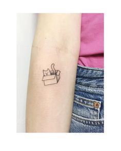 a small cat in a box tattoo on the left inner arm and shoulder, it's outline