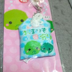 a key chain with an animal design on it's front and back ends are attached to a plastic package