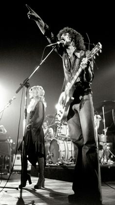 two people on stage with guitars and microphones