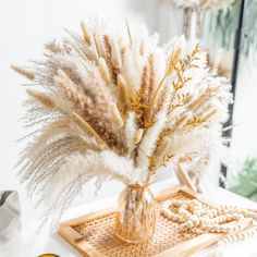 a vase filled with lots of white flowers on top of a wooden tray next to a mirror