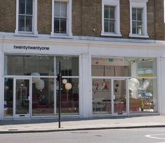 an empty street corner in front of a storefront with balloons hanging from it's windows