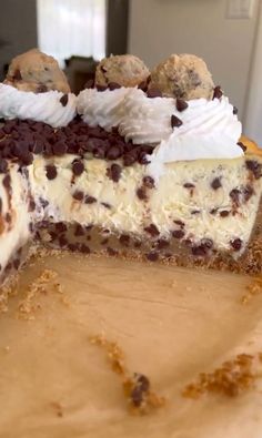 a cheesecake with chocolate chip cookies and whipped cream on top is cut in half