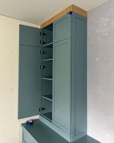 an empty room with blue cupboards and drawers in the corner on the wall is a night sky painted on the wall