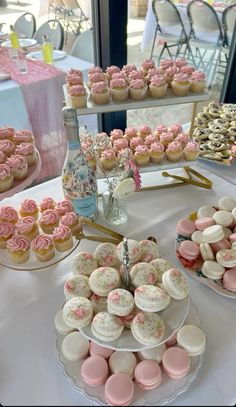 a table topped with lots of cupcakes and cakes