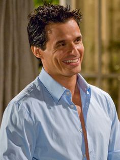 a man smiling and wearing a blue shirt