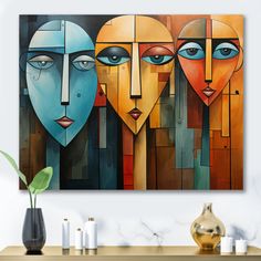 three faces are depicted in an abstract painting on the wall above a table with candles and vases