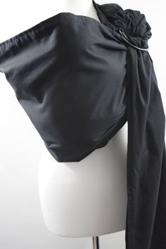 a white mannequin with a black scarf on it