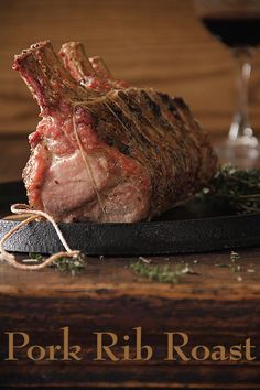 a piece of meat sitting on top of a plate next to a glass of wine