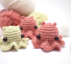 several crocheted octopus toys are sitting next to each other on a white surface