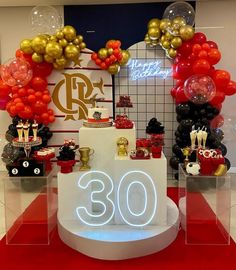 a table with balloons, cake and decorations on it in front of a sign that says 30th