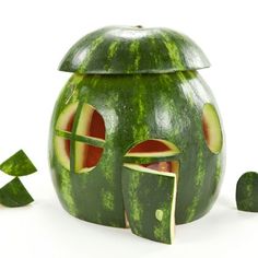 a watermelon shaped like a house with slices cut out to make it look like a face