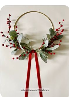 a wreath with red berries and greenery on it