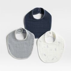 three bibs with blue and white designs on them