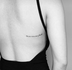 the back of a woman's left shoulder with a small tattoo on her right side